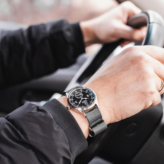 Person driving a car with a Techné Merlin watch on their wrist